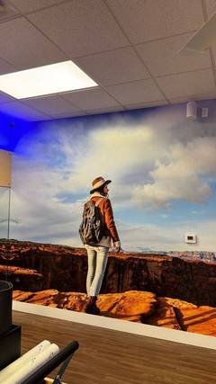 Custom vinyl wall wrap of a hiker on a red-rock canyon overlook inside a business